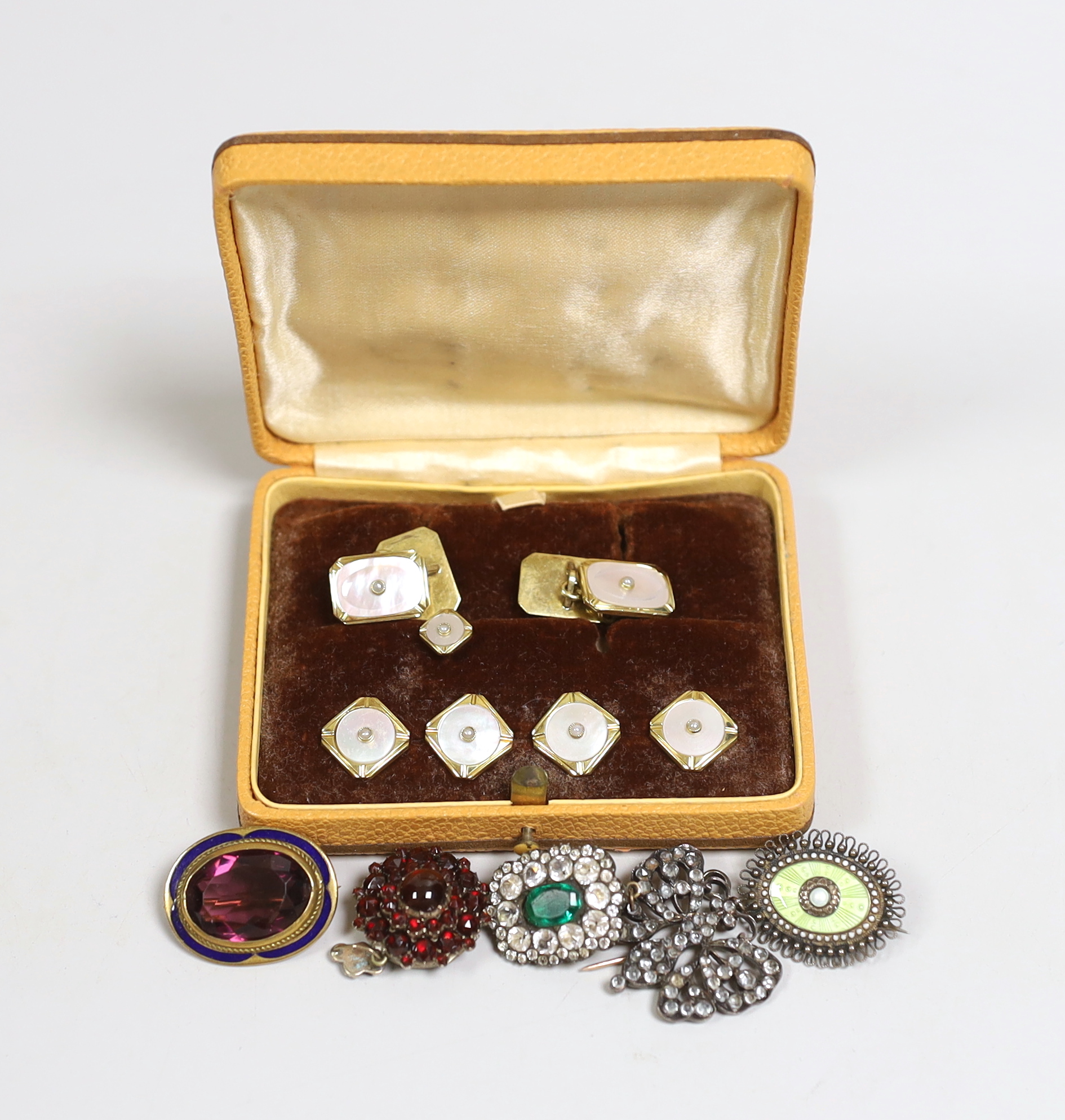 Victorian and later jewellery including a gilt metal, amethyst paste and enamelled oval brooch, 26mm, a garnet set mourning brooch with plaited hair, two paste set brooches, a cased dress stud set and a Scandinavian 830s